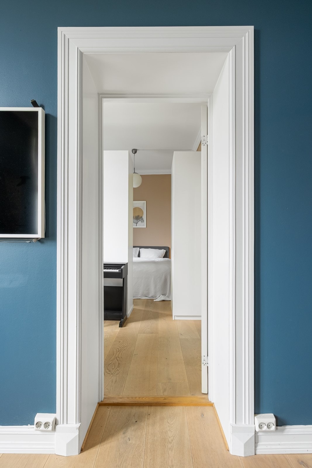 Rommet har parkettgulv og vegger malt i en lun blåfarge, som står i fin kontrast til de hvite detaljene. Galleribilde