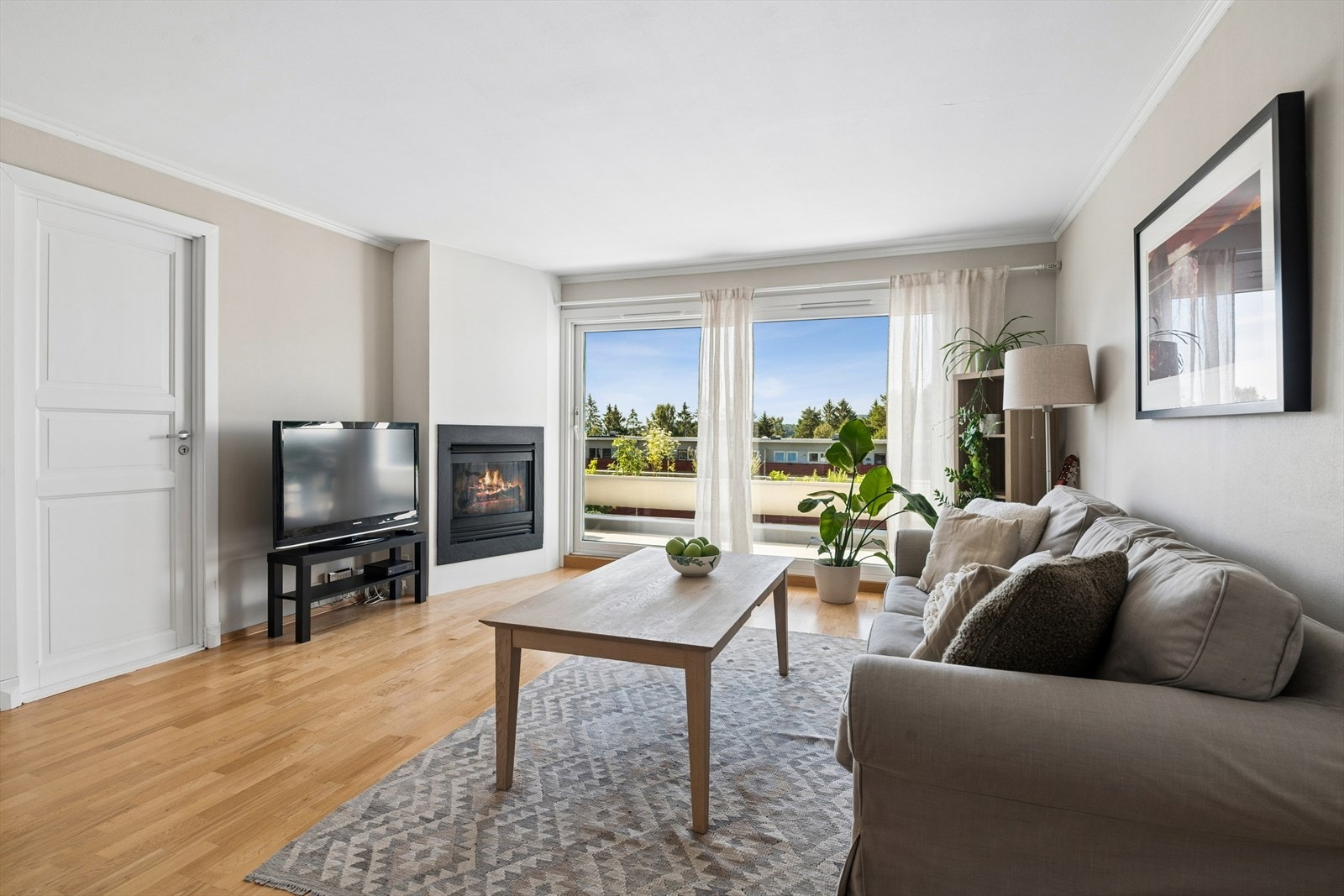 Lys og hyggelig stue med gasspeis og nyere vinduer/skyvedør fra gulv til tak Galleribilde