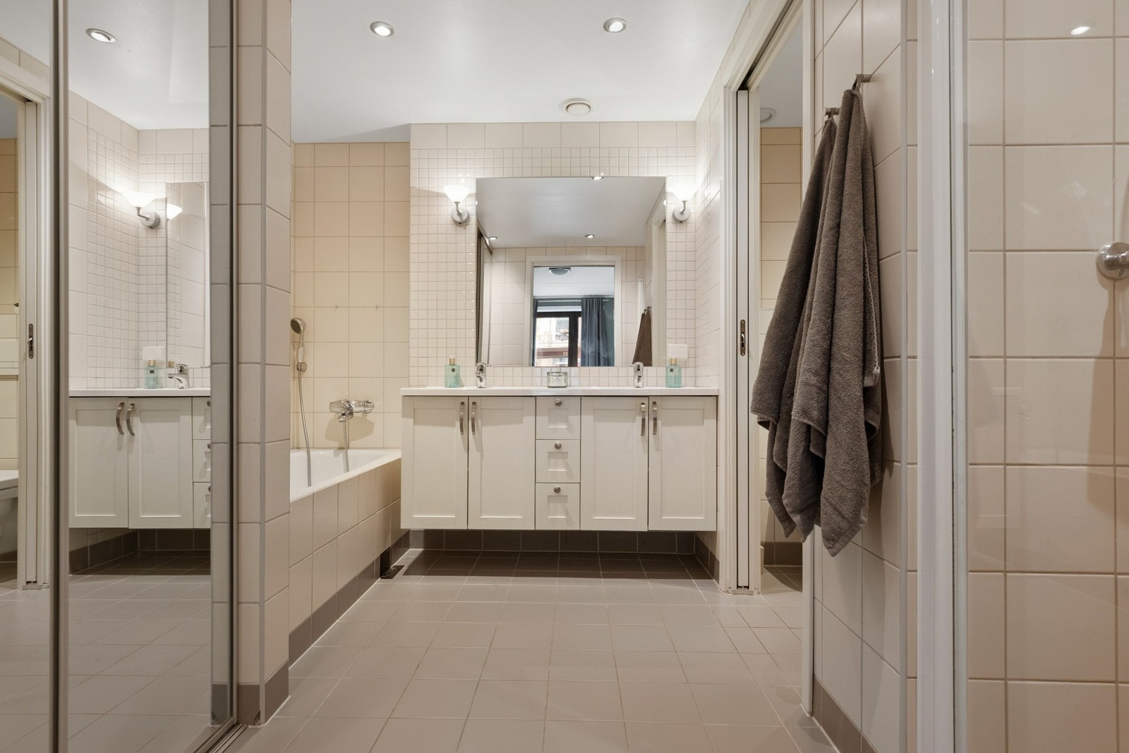 Pent baderom med flislagte overflater, gulvvarme og opplegg for vaskemaskin. Galleribilde