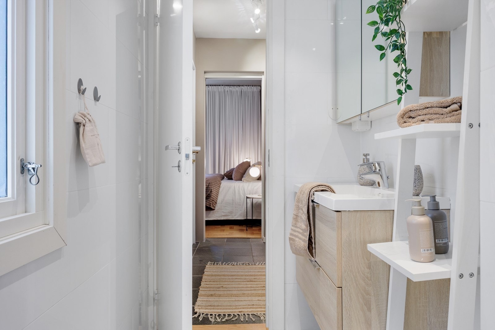 Badet er innredet med vegghengt toalett, helstøpt servant med møblement, og dusjdører i klart glass. Galleribilde