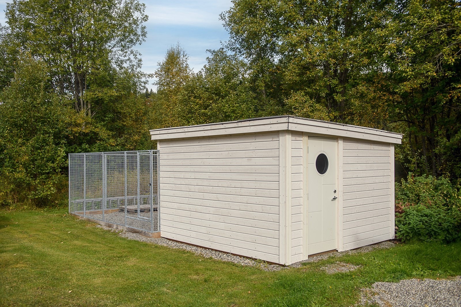 Frittstående uthus med tilhørende inngjerdet hundegård på tomten. Galleribilde