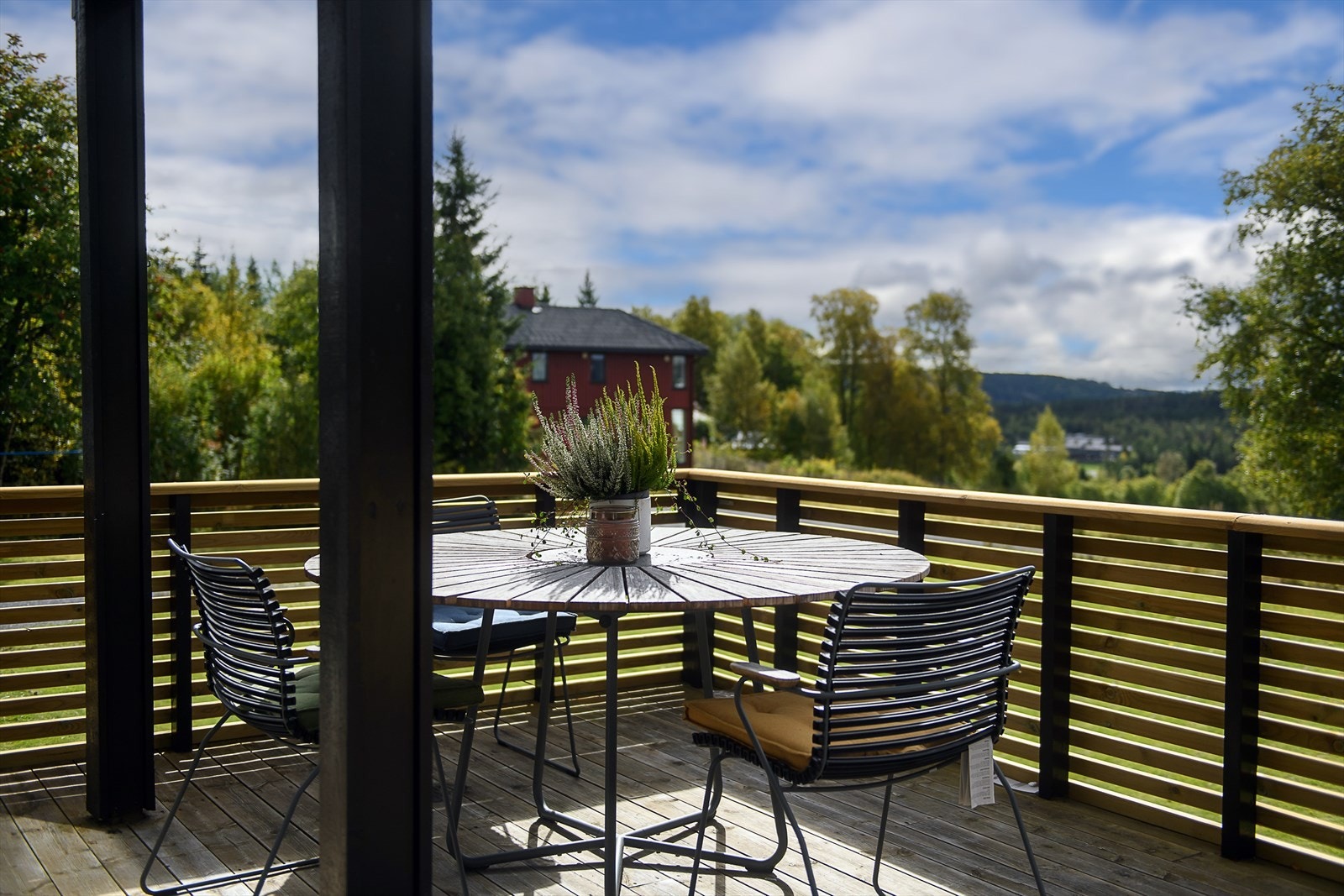 Terrassen har spilerekkverk i treverk og utsikt mot nærområdet. Galleribilde