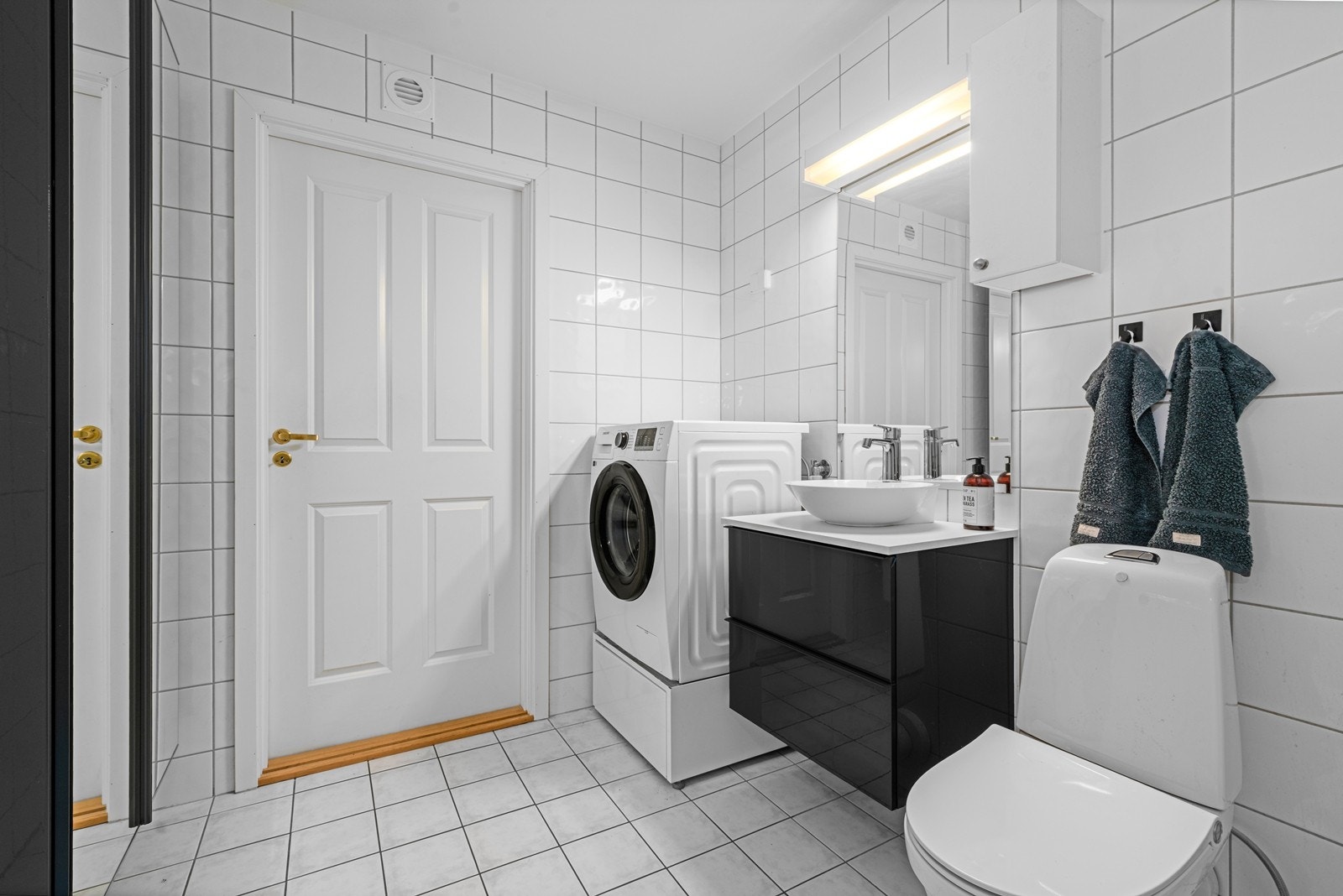 Badet er utstyrt med vegghengt servantinnredning og har opplegg for vaskemaskin. Galleribilde