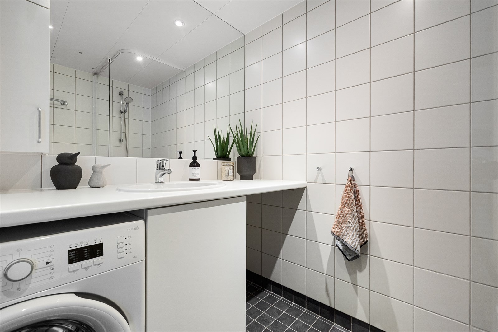 Badet er fra byggeår og består av elektriske varmekabler i gulvet, downlights i taket og opplegg til vaskemaskin. Galleribilde