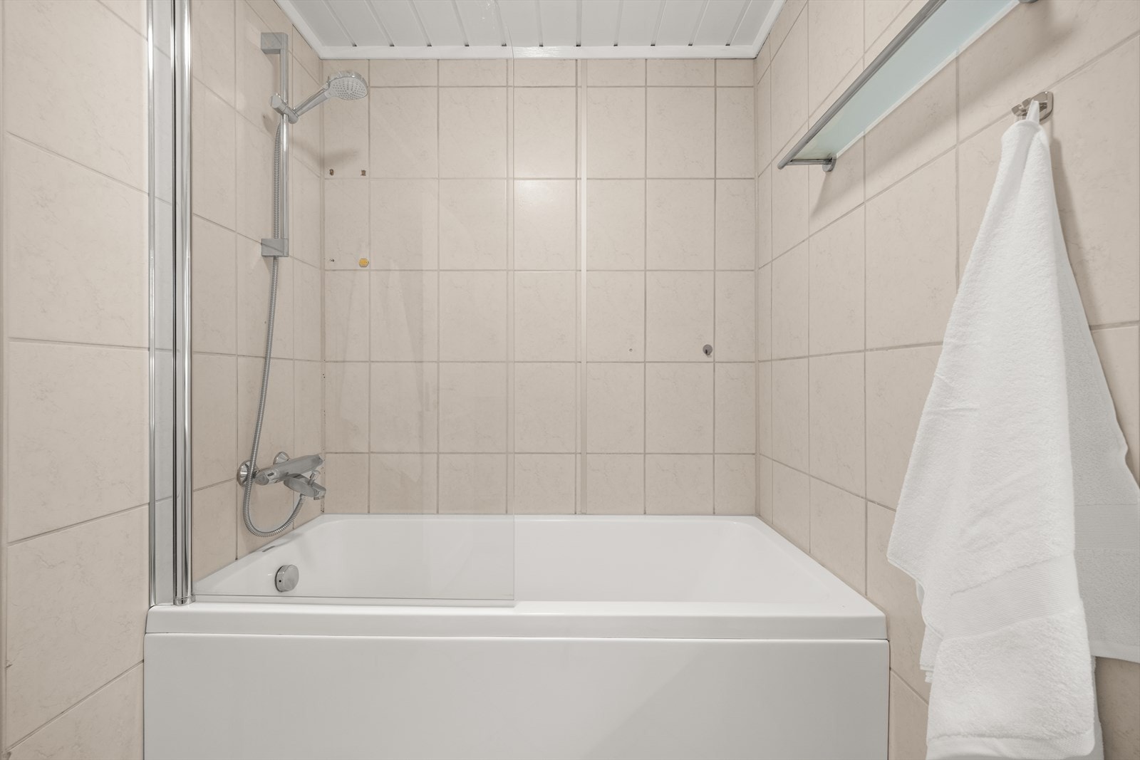 Badet er utstyrt med heldekkende servant med underskap, speil med lys og badekar med dusj Galleribilde