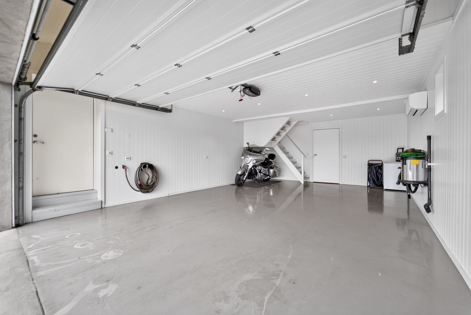 Stor garasje med epoxylagt gulv og varmepumpe på vegg. Galleribilde