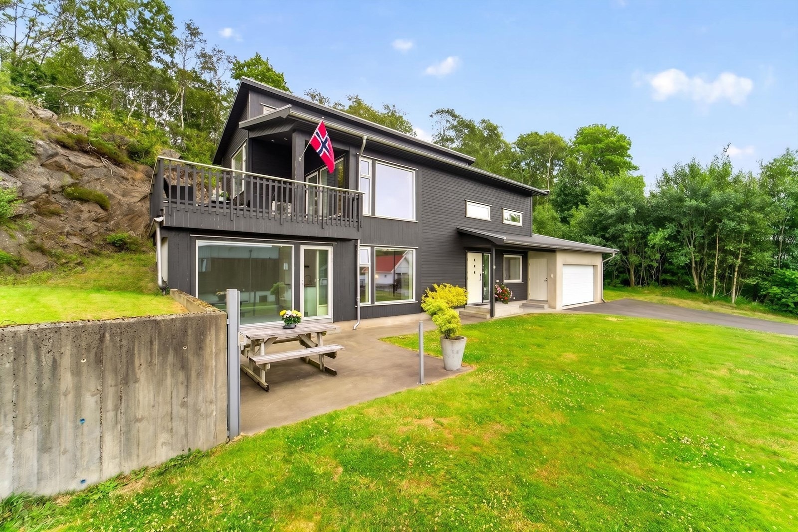 Pent opparbeidet uteområde med romslige plenarealer, terrasse og gode solforhold. Tomten grenser mot naturskjønne omgivelser og byr på god plass til både lek, aktivitet og avslapning. Galleribilde