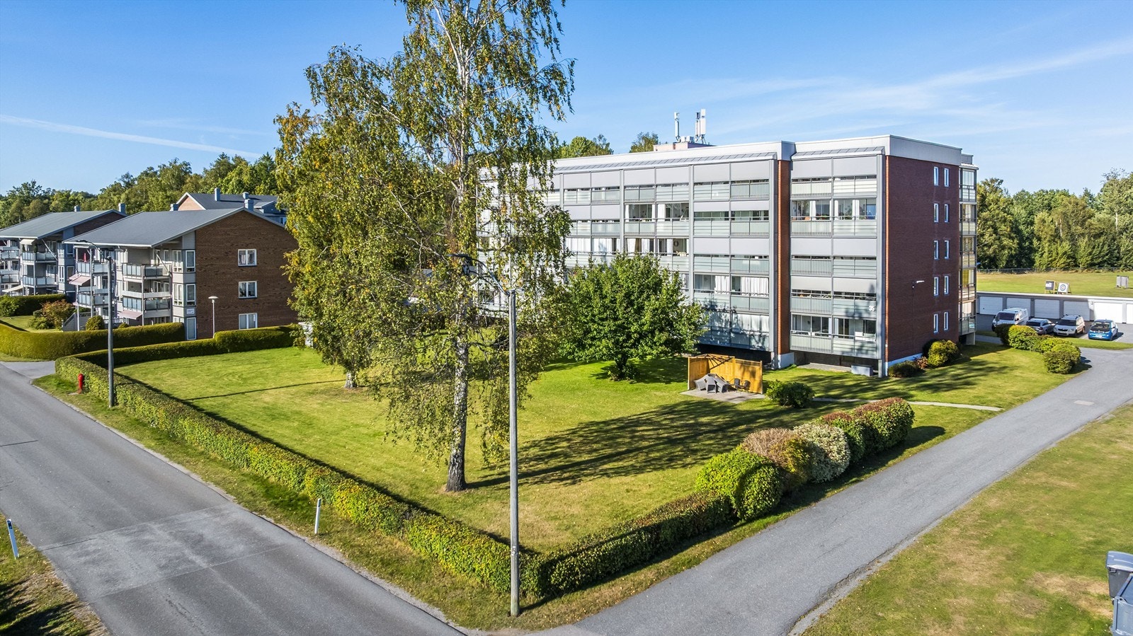 Fellestomten er pent opparbeidet med asfalterte gangveier og frodig beplantning. Galleribilde