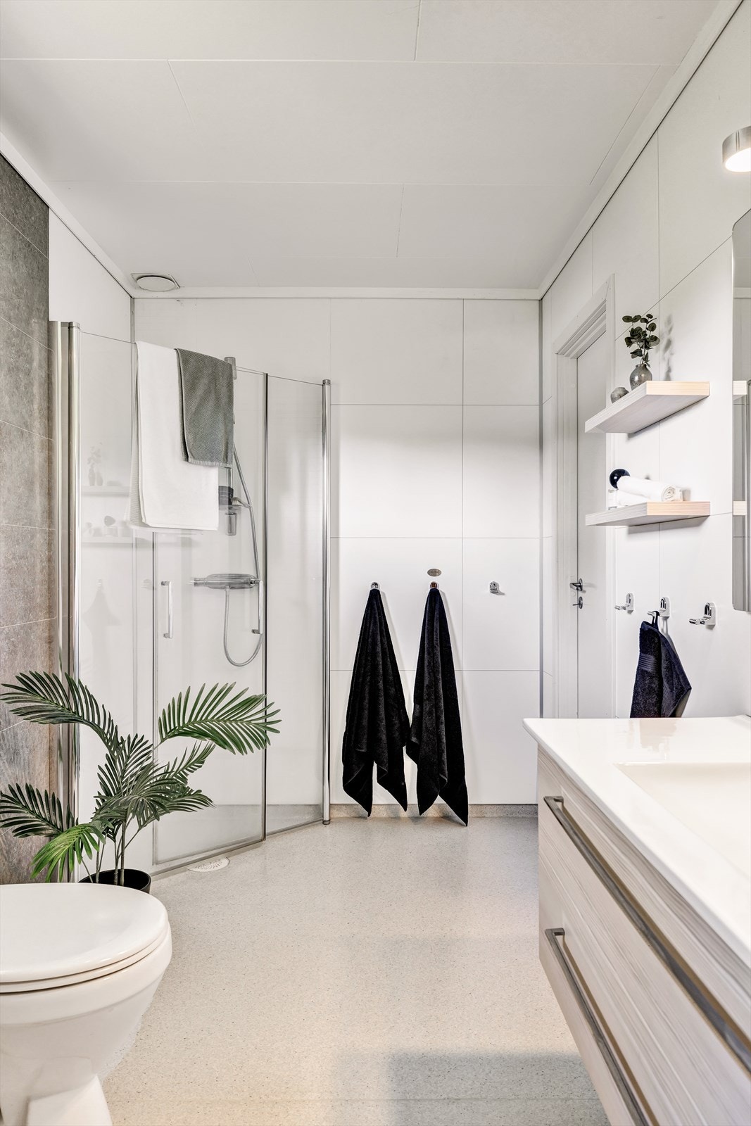 Badet har innredning med nedfelt servant og er innredet med gulvstående toalett og dusjhjørnet. Galleribilde