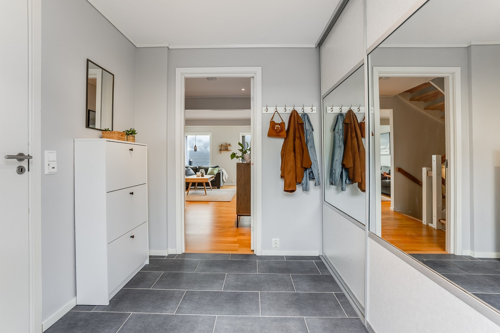 Entre med flislagt gulv med gulvvarme. Skyvedørsgarderobe med gode oppbevaringsmuligheter Galleribilde