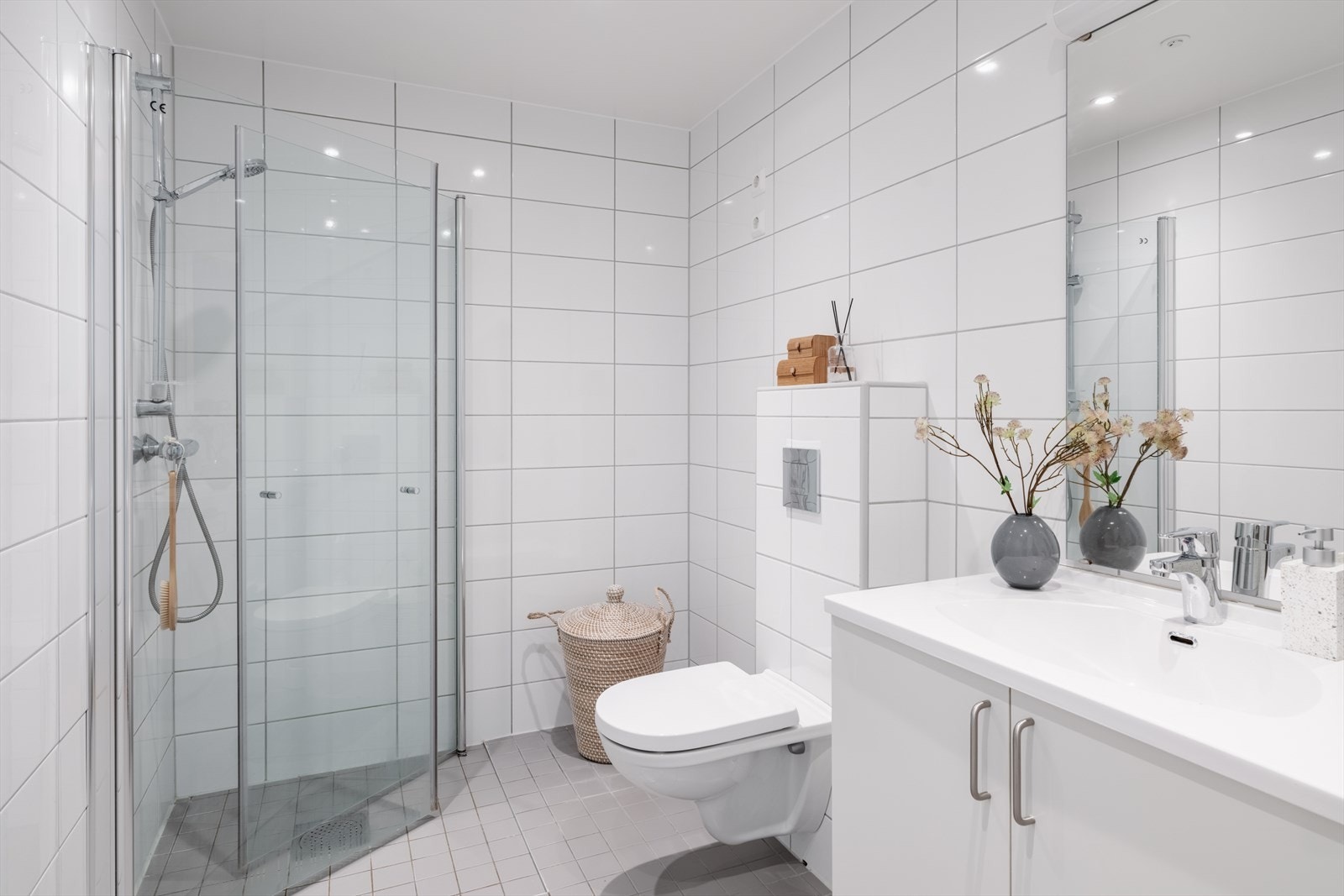 Badet er fra byggeåret 2017 og har en moderne utførelse med flislagte overflater og elektriske varmekabler i gulvet, som sørger for behagelig gulvvarme. Rommet har en god størrelse og fremstår både funksjonelt og innbydende. Galleribilde