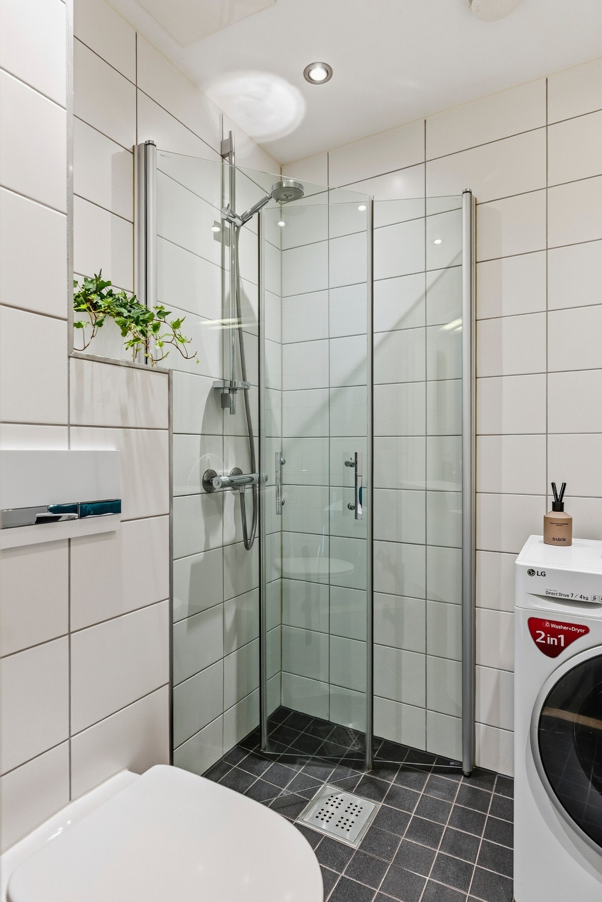 Badet har gulvvarme og dusjhjørne med svingbare glassdører som kan foldes inn når dusjen ikke er i bruk. Galleribilde