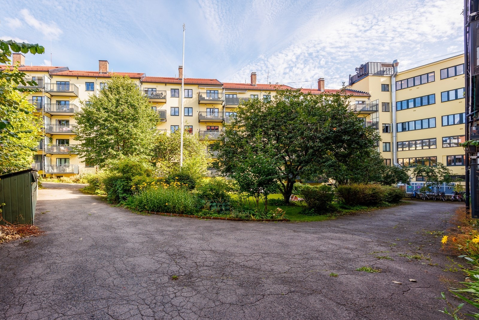Borettslagets bakgård byr på grønne omgivelser mellom bygningene. Sykkelparkering i bakgård Galleribilde