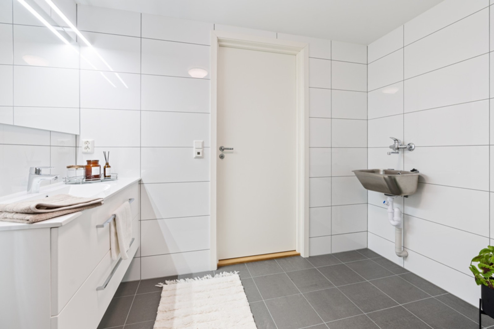Du vil oppleve baderommet som lyst og delikat. Legg merke til den smarte løsningen for vaskemaskin. Denne kan dekkes til av en skyvedør om man ønsker. Galleribilde