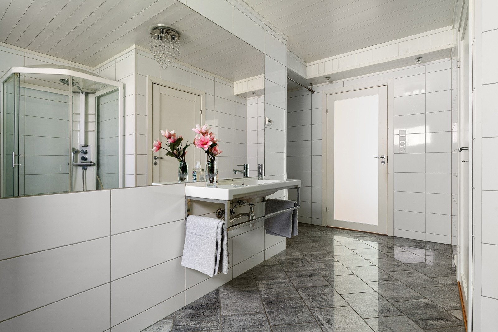Boligen har to bad, ett i hver etasje. Badet i hovedetasjen er utstyrt med dusjkabinett, toalett og speil langs hele veggen.