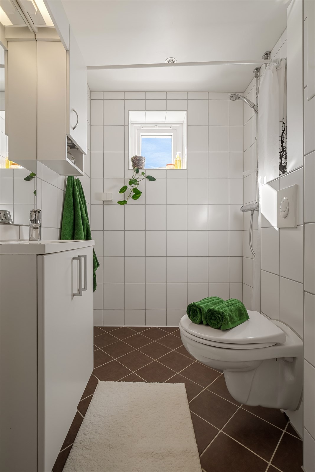 Innredningen består av servant, veggmontert wc, dusjvegger og opplegg for vaskemaskin. Galleribilde