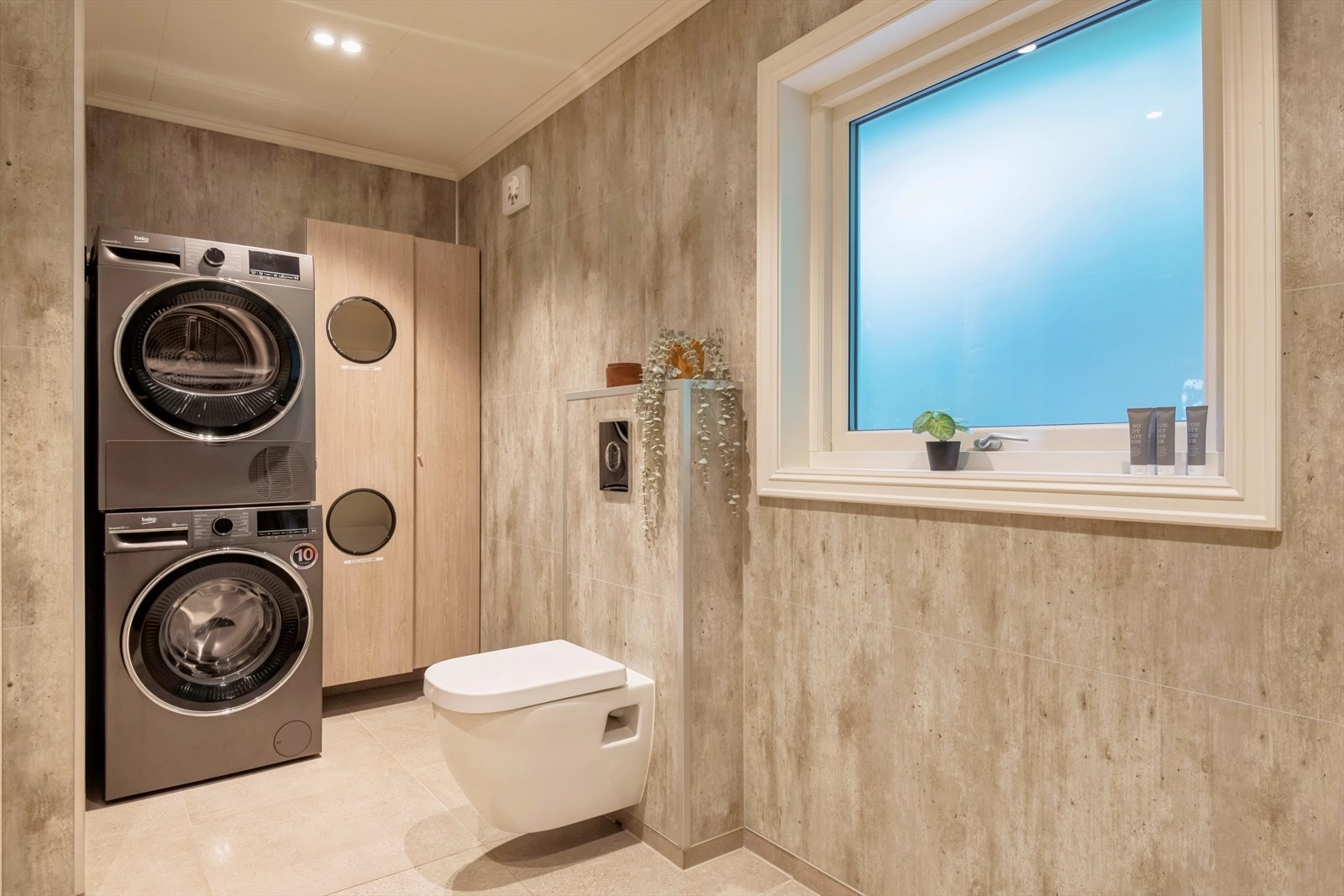 Badet er pent laget til med egen del for vaskemaskin Galleribilde