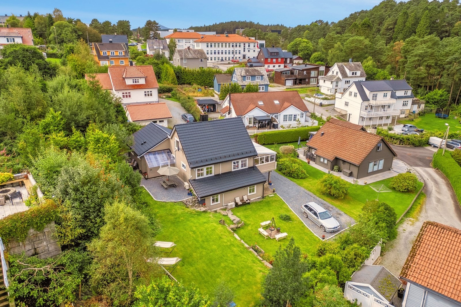Tomten er godt tilpasset både lek og rolige dager, med gressplener i flere nivåer, hagestue og stor terrasse Galleribilde