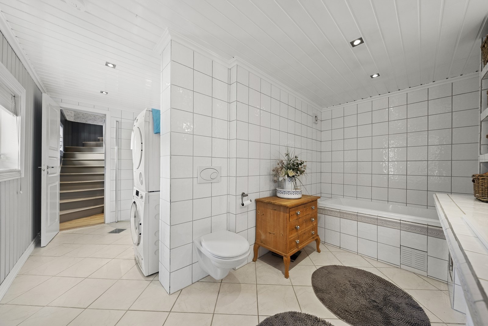 Badet er utstyrt med toalett, badekar, dusj, servant og plass til vaskemaskin. Galleribilde