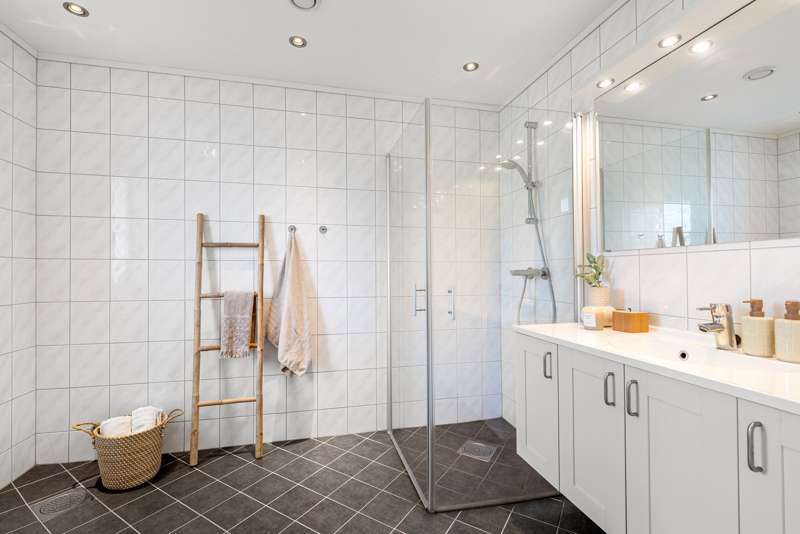 Flislagt bad i 1. etasje med gulvvarme, downlights og dusjhjørne med innfellbare glassdører. Galleribilde