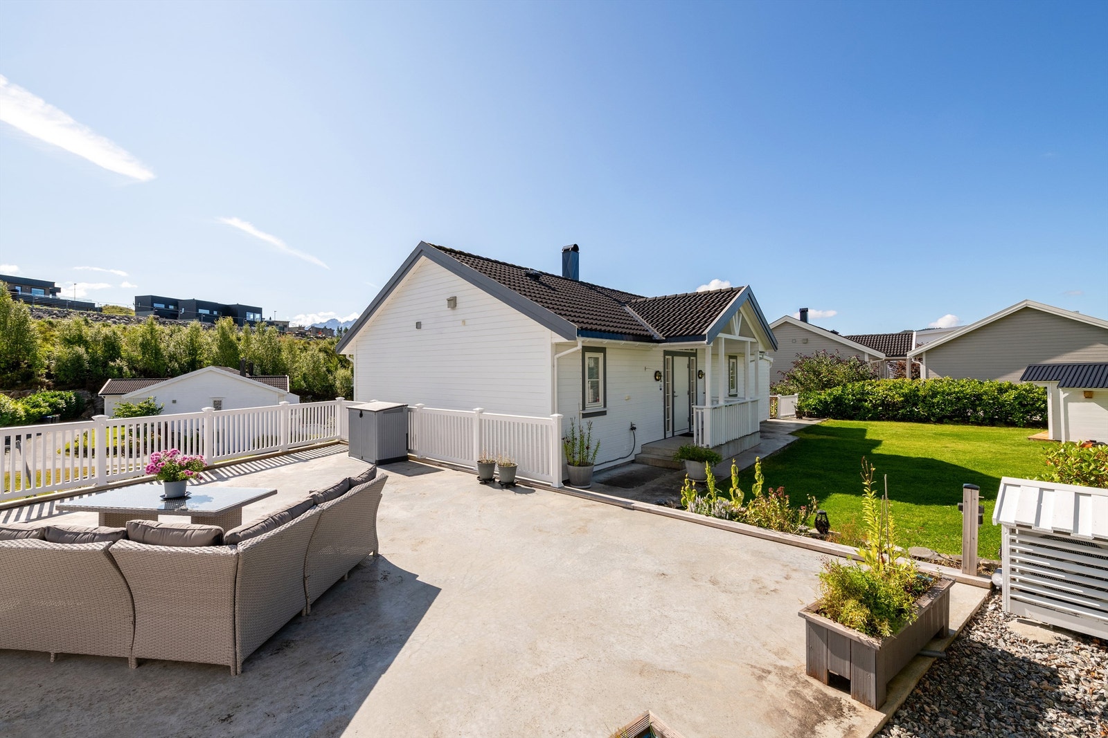 Stor takterrasse over garasjen i betongkonstruksjon med hvitt rekkverk. Galleribilde