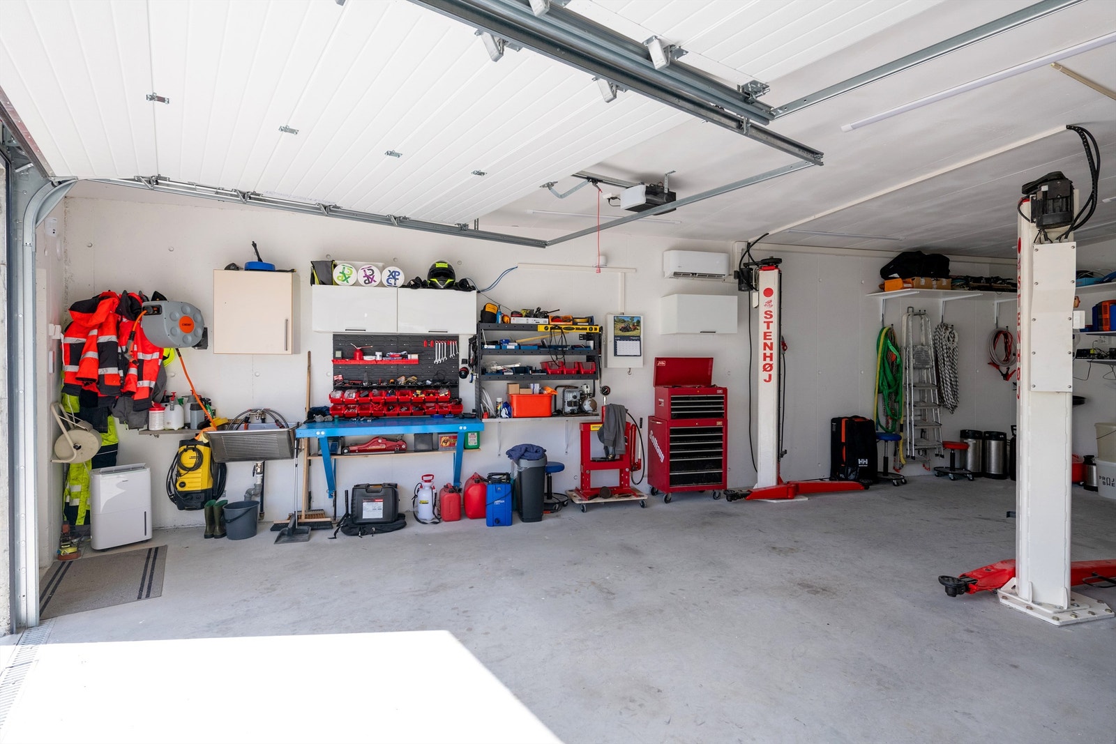 Garasjen er innredet med gode lagringsmuligheter og romslig plass for arbeidsbenk. Galleribilde
