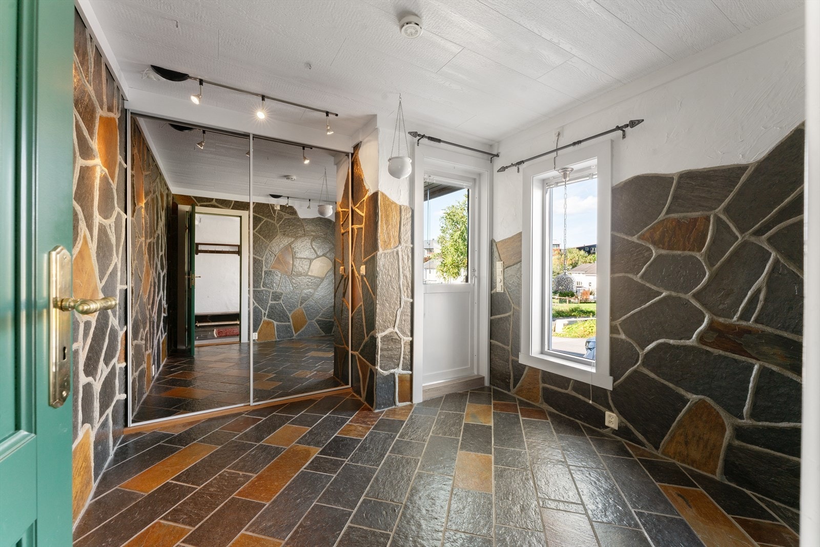 Praktisk rom i tilknytning til entréen med stor skyvedørsgarderobe med speilfronter. Fra rommet er det også utgang til balkong. Galleribilde