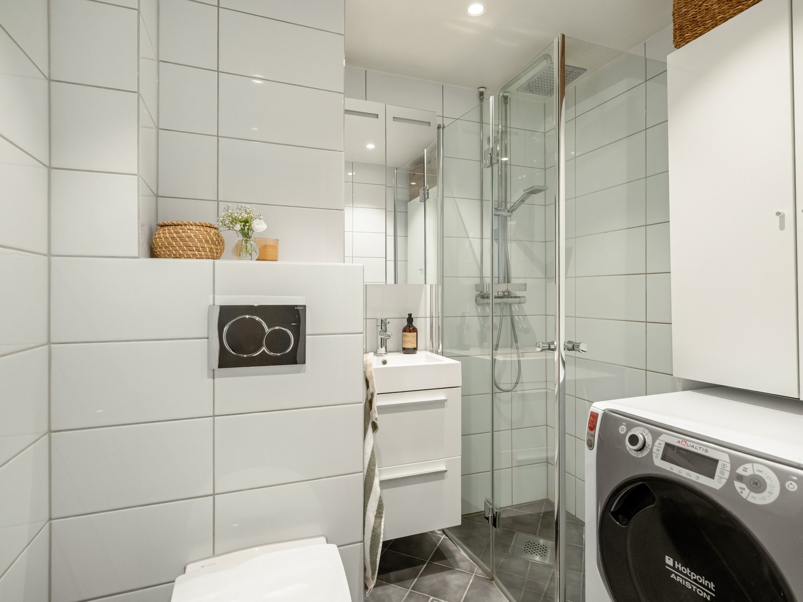 Badet er innredet med alt du trenger av vaskemaskin, servant med innredning, regnfallsdusj og vegghengt wc. Galleribilde