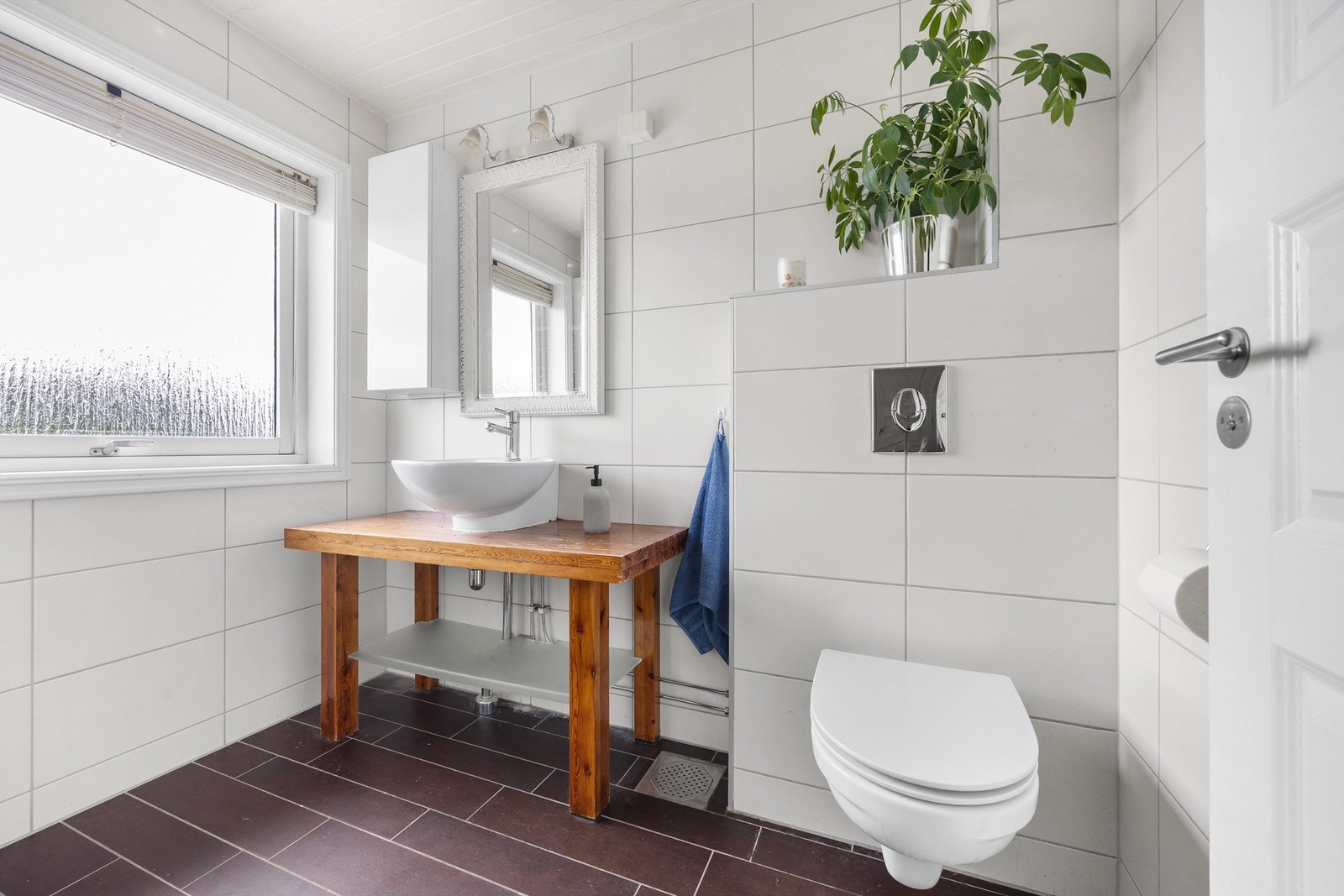 Baderommet har servantmontering på trebenk og vegghengt toalett. Galleribilde