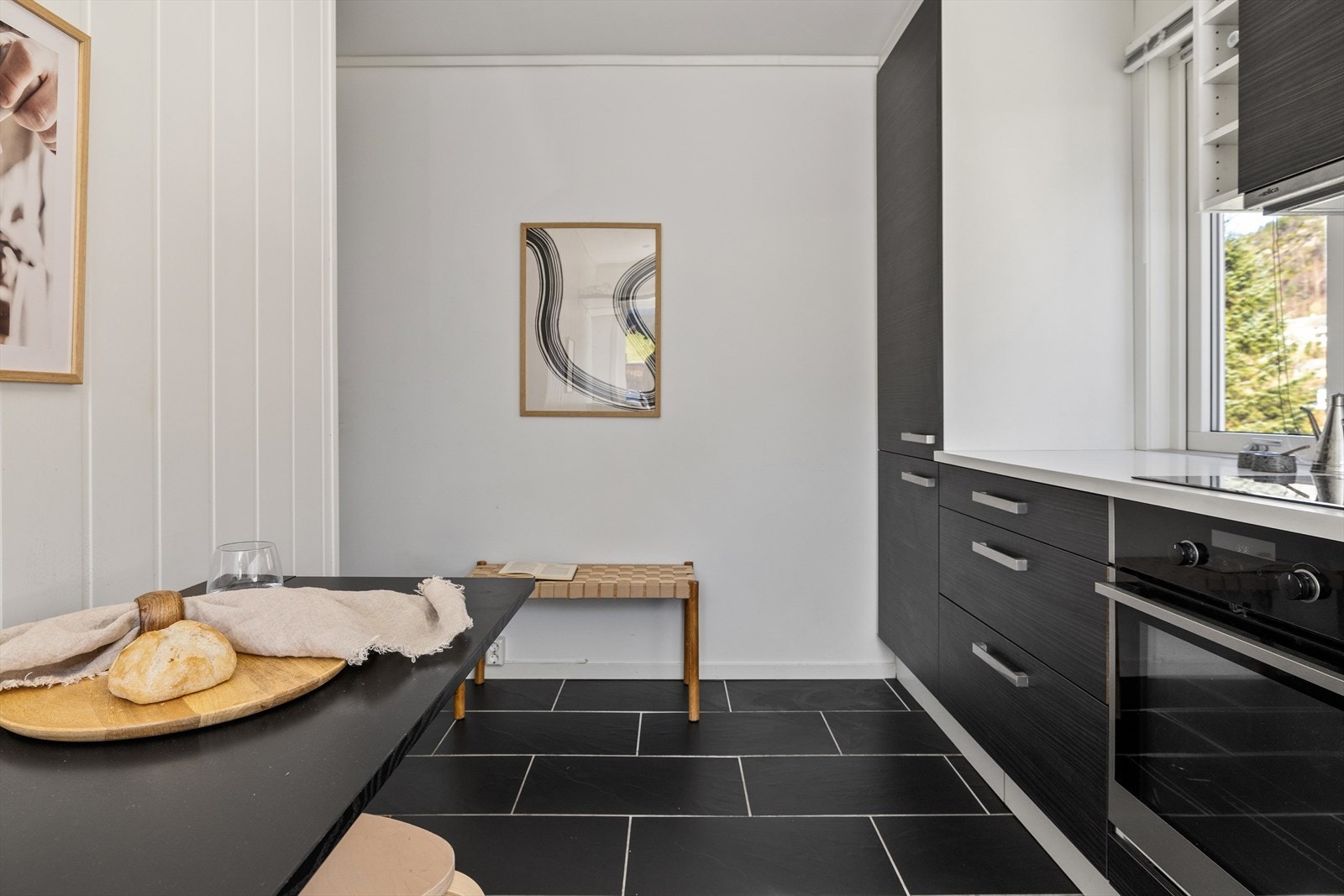 Boligen har lukket kjøkkenløsning med flislagt gulv og downlights i himling. Galleribilde