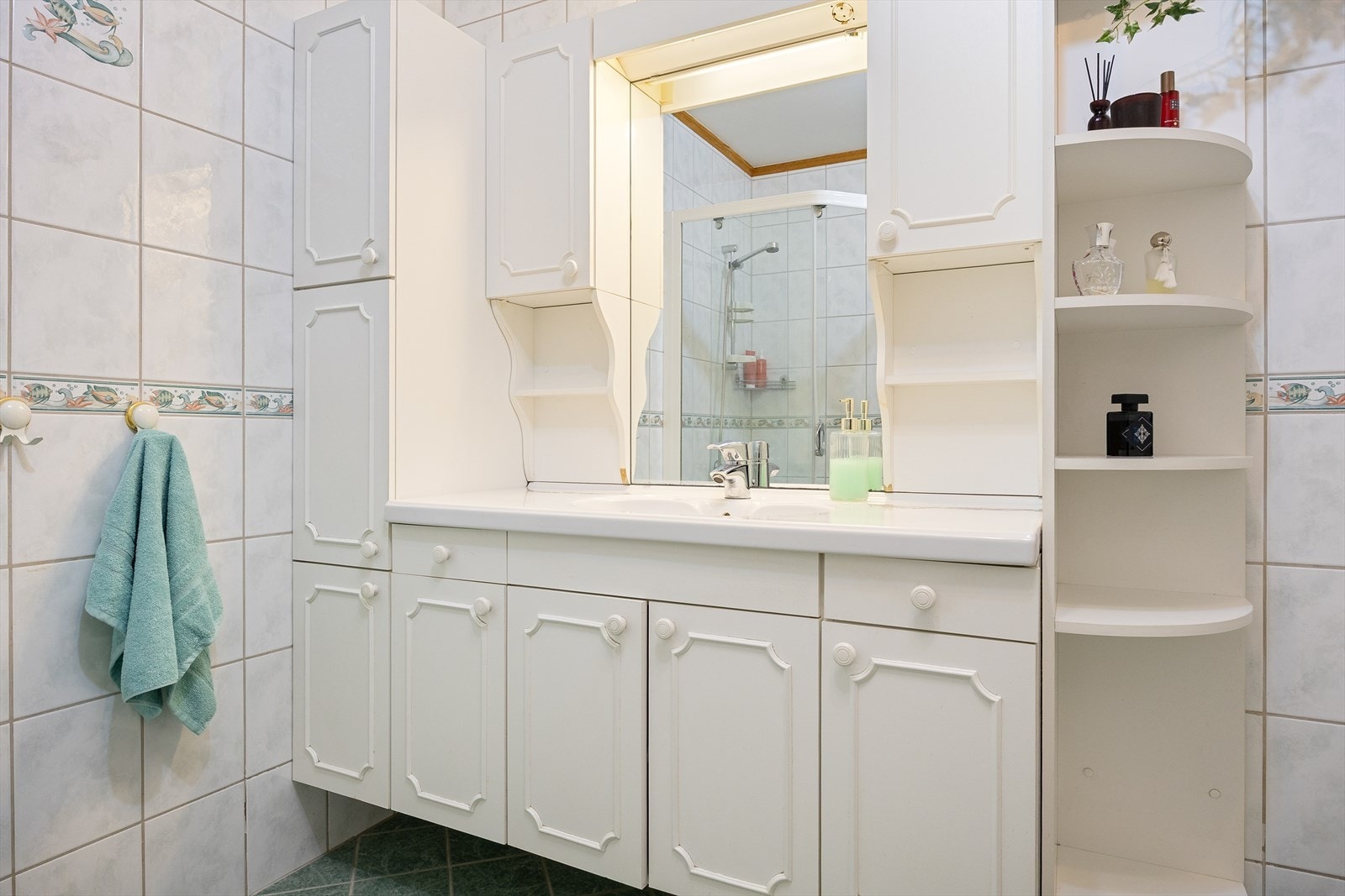 Badet er innredet med dusj, toalett, og servant med baderomsmøblement. Galleribilde