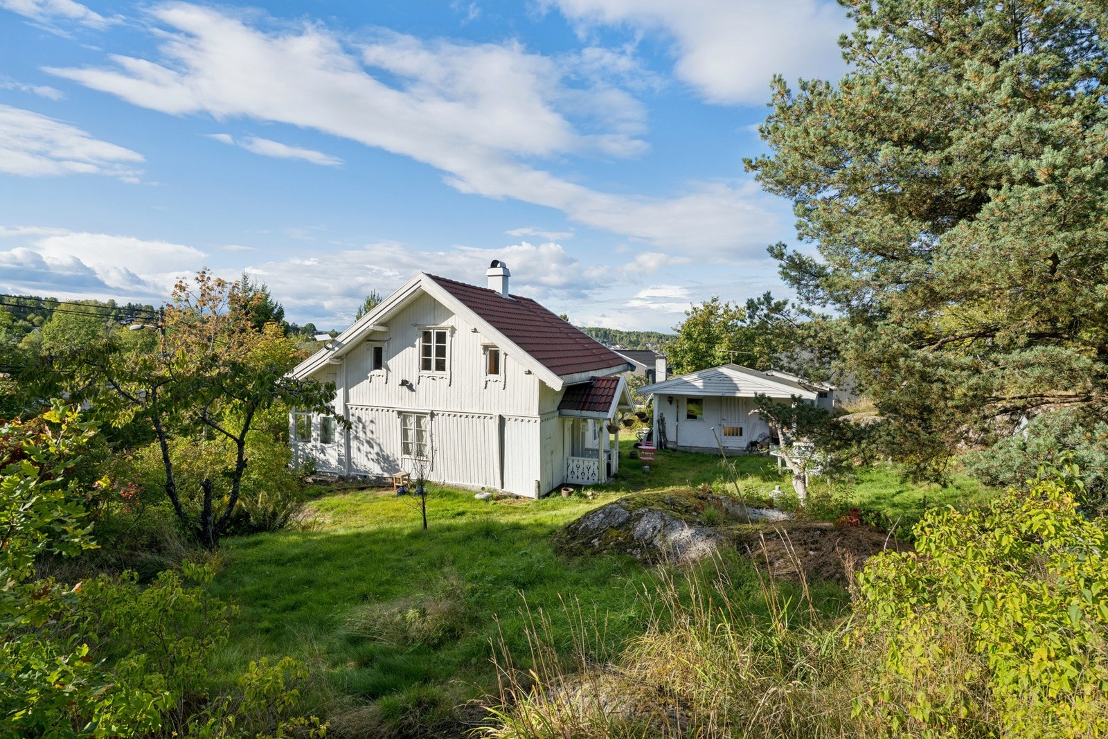 Boligen ligger landlig og tilbaketrukket på en romslig, naturpreget tomt med etablert vegetasjon. Galleribilde