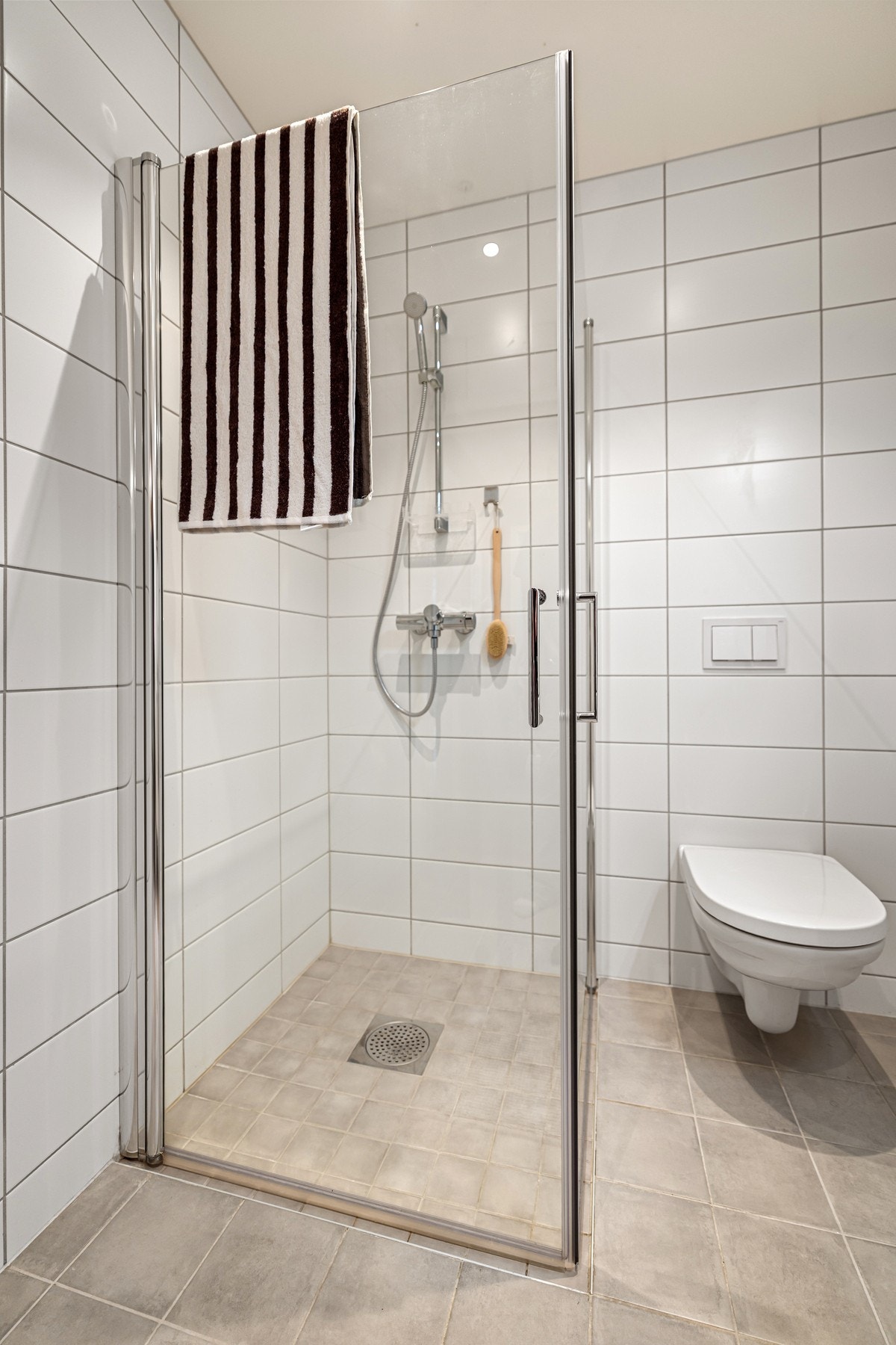 Badet er innredet med nedfelt servant, veggmontert toalett og dusjvegger/hjørne. Galleribilde