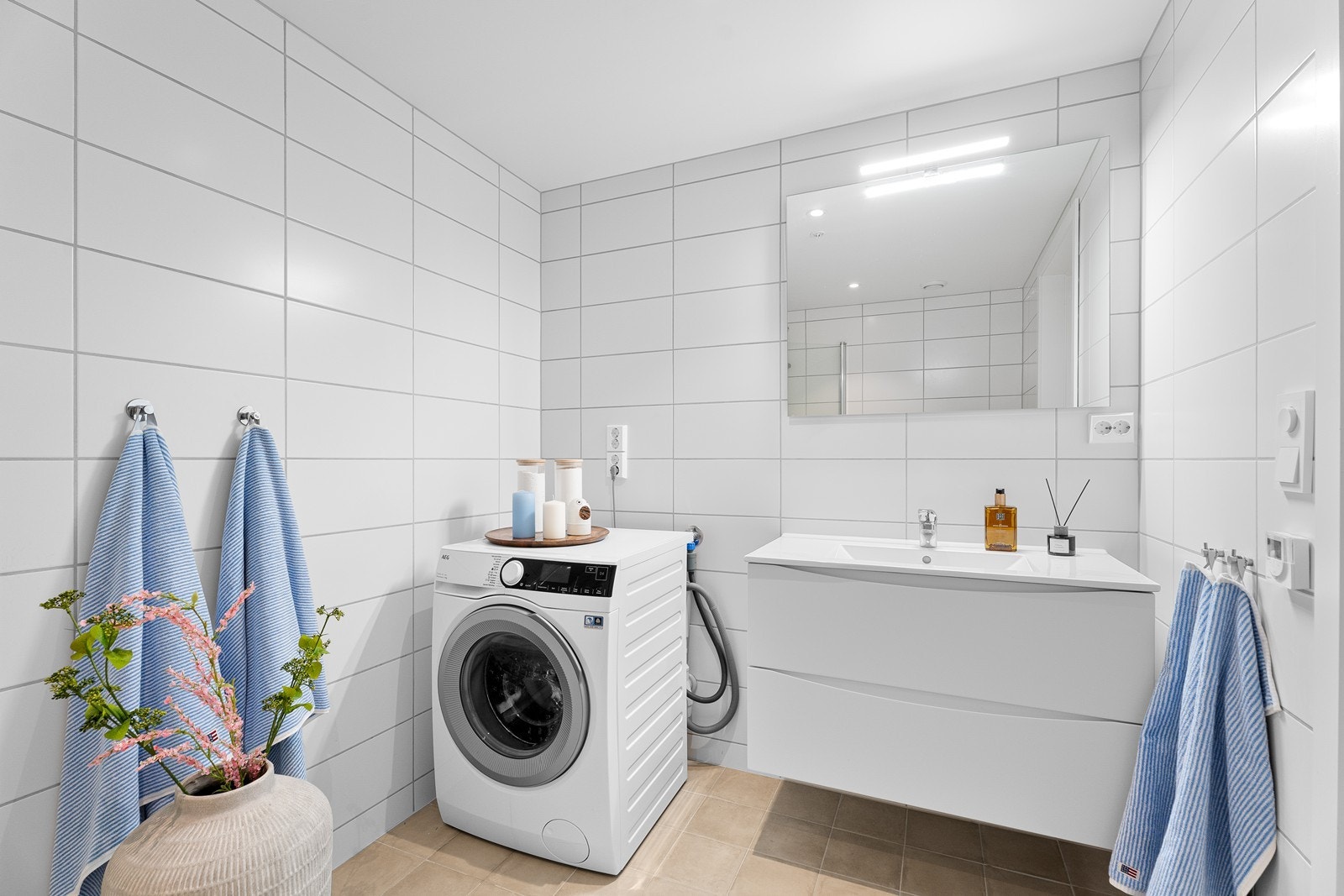 Romslig bad med innredning, stort speil og opplegg for vaskemaskin. Galleribilde