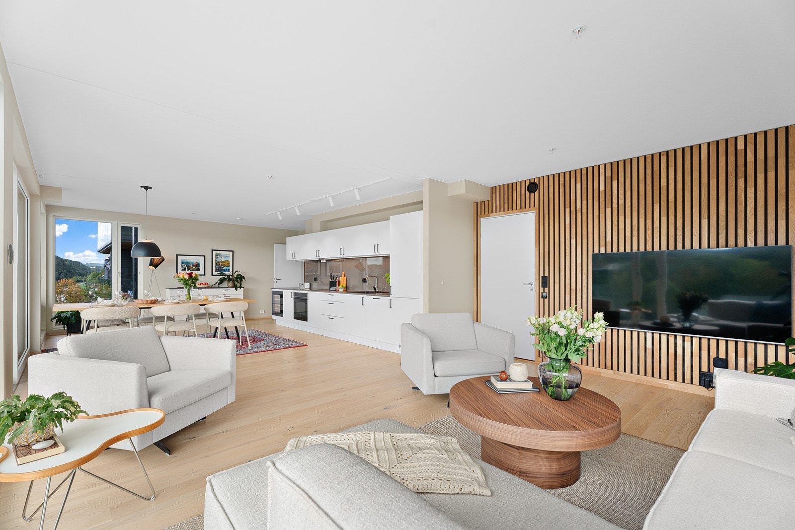 Romslig og moderne oppholdsrom med åpen løsning og stilrene materialvalg. Galleribilde
