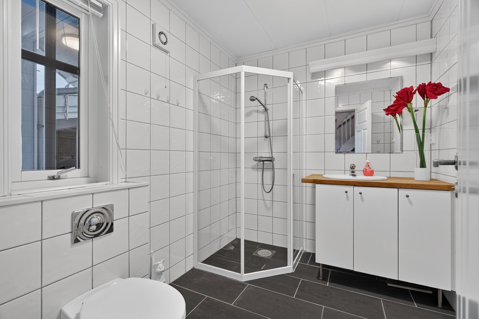 Badet er av god størrelse, innredet med dusjkabinett, vegg montert toalett og servant. Galleribilde