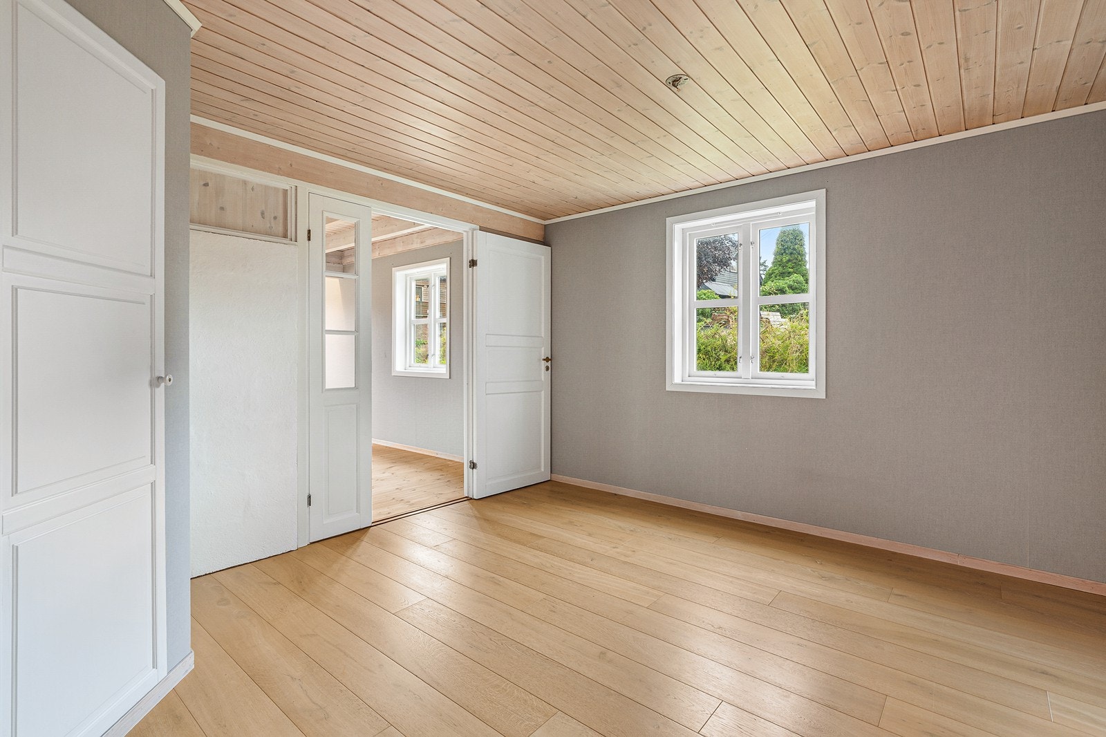 Tv-stuen har laminat på gulv, malte vegger og tapet Galleribilde
