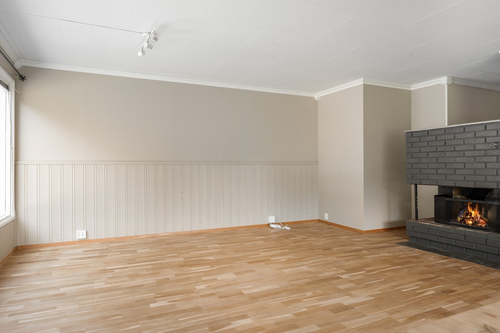 Stuen har fine møbleringsmuligheter og med en koselig peis. Galleribilde