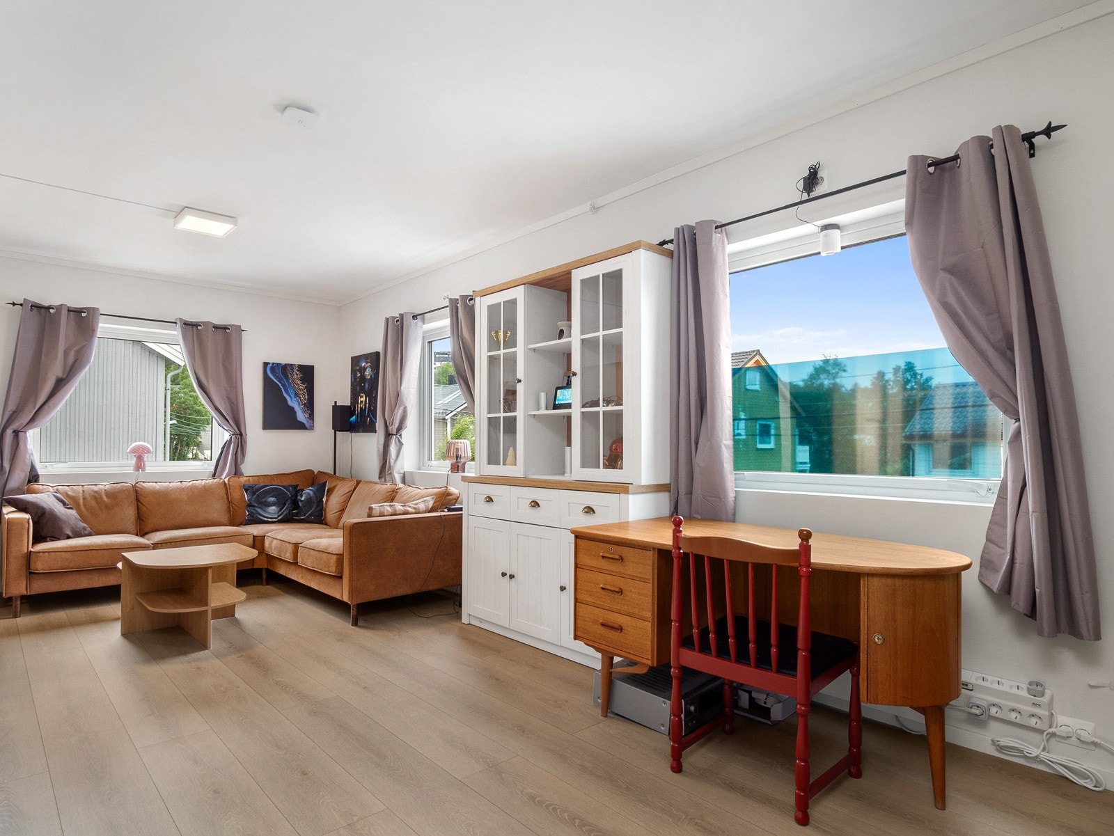 Stuen har god plass til sittegruppe og spiseområde, og det er store vinduer som gir godt lysinnslipp Galleribilde