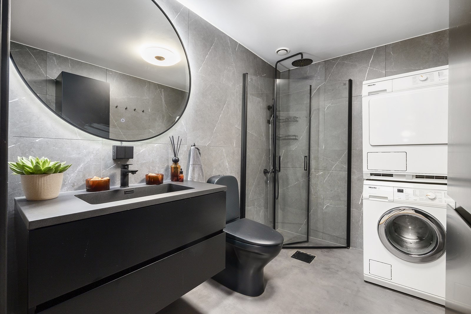 Badet er delikat oppgradert med mikrosement, flislagte vegger og downlights. Gulvvarme, moderne innredning og opplegg for vaskemaskin gir god komfort i hverdagen. Galleribilde