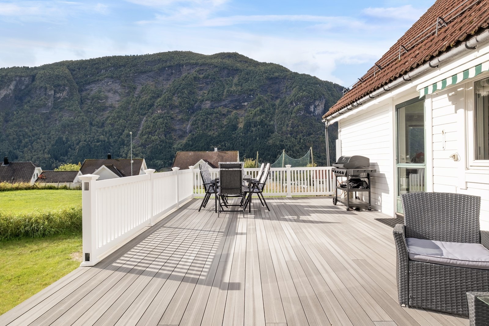 Romsleg terrasse med tilkomst frå stove/kjøkken og vidare ned til hagen. Galleribilde
