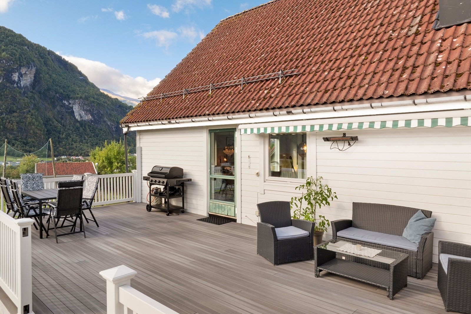 Terrasse utanfor stova bygd på betongfundament med trekonstruksjonar og komposittgolv. Galleribilde