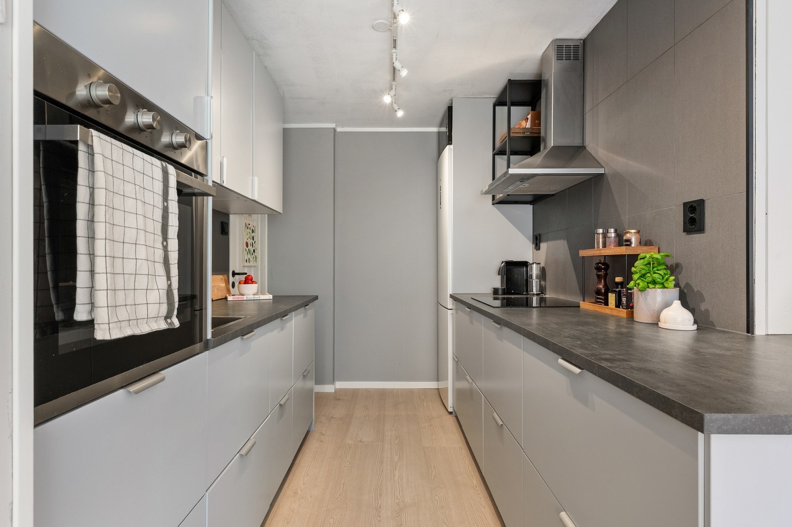 Innredningen har et stilrent uttrykk med glatte fronter, laminatbenkeplate og fliser over arbeidsflatene. Galleribilde