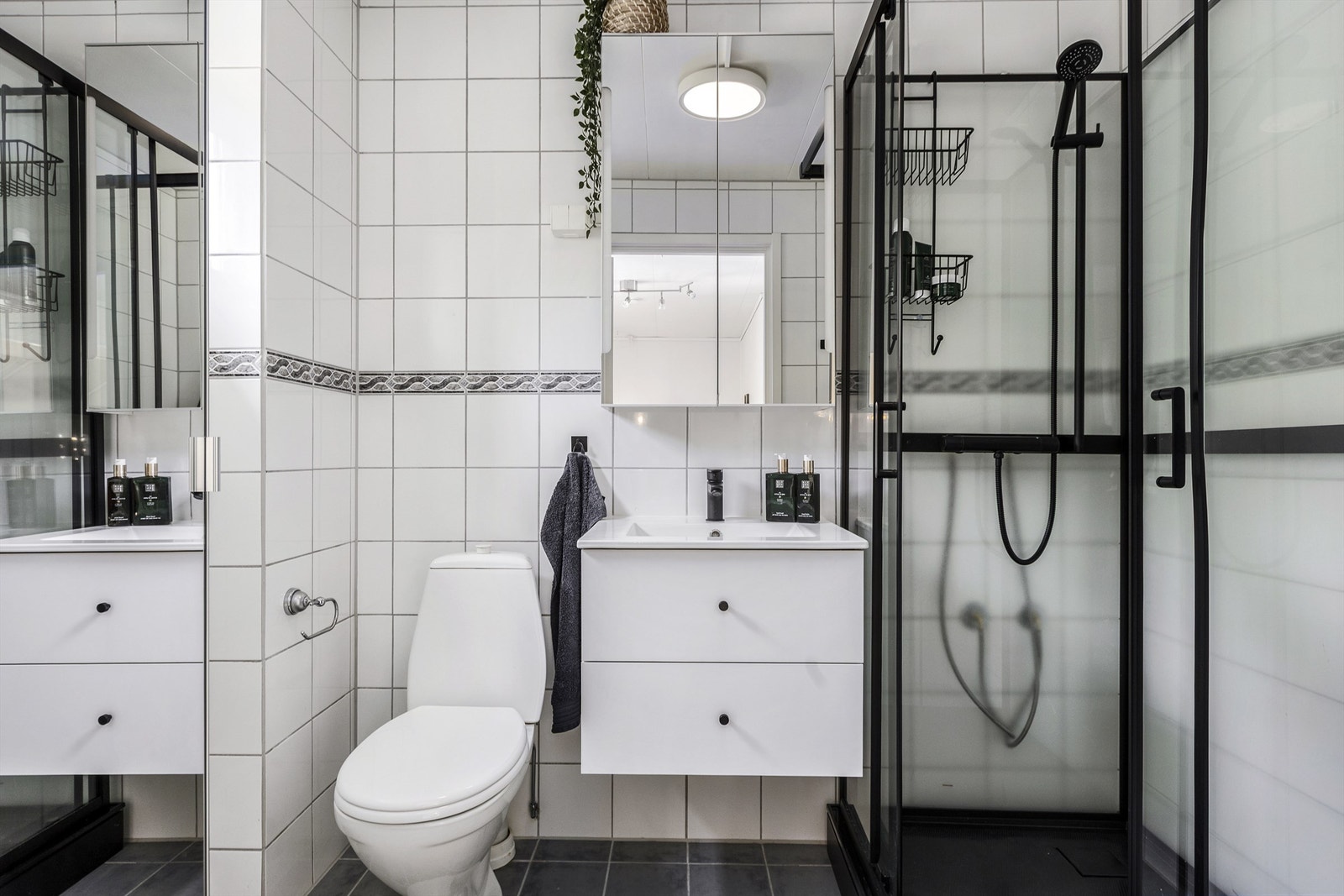 Flislagt bad i 2. etasje med gulvvarme, dusjkabinett og vegghengt servantinnredning. Galleribilde