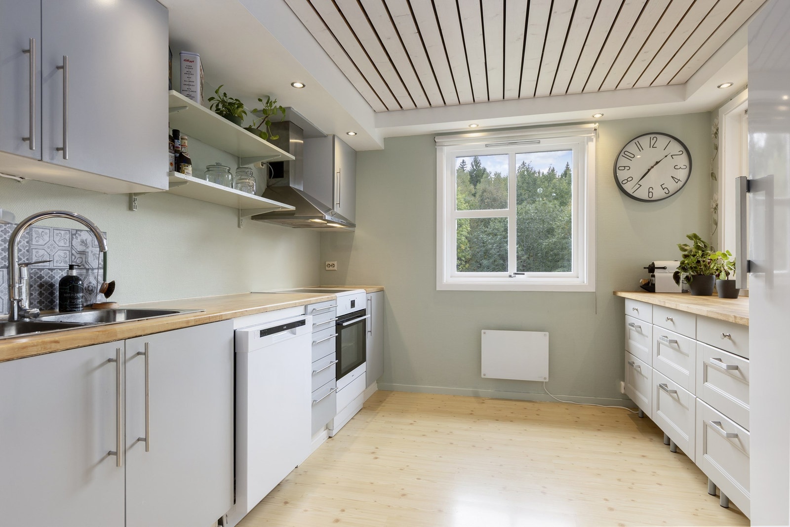 Kjøkkenet har godt med skapplass og arbeidsflater på to sider. Galleribilde