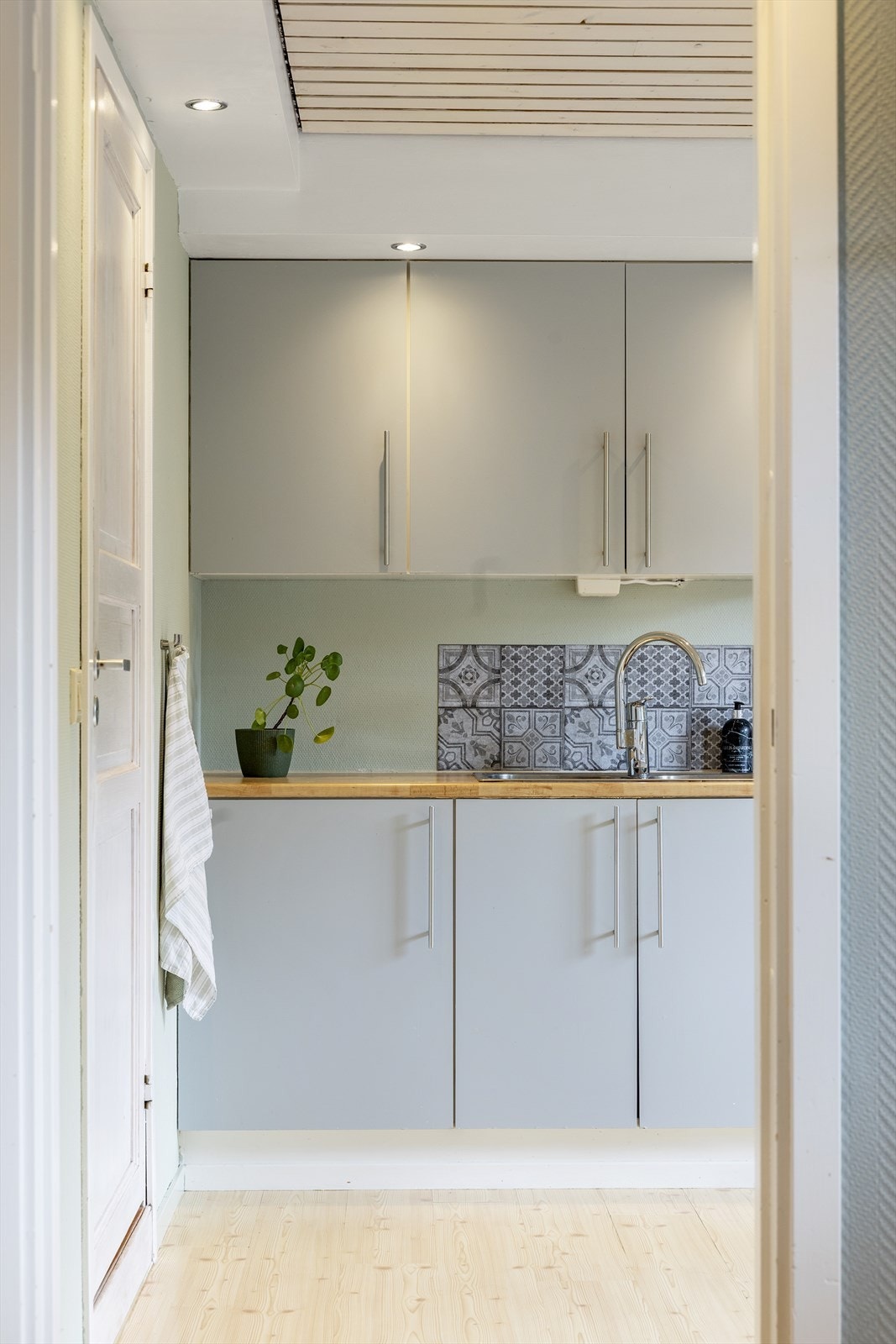 Separat kjøkken med adkomst fra stuen, innredet med trepanel og downlights i himling. Galleribilde