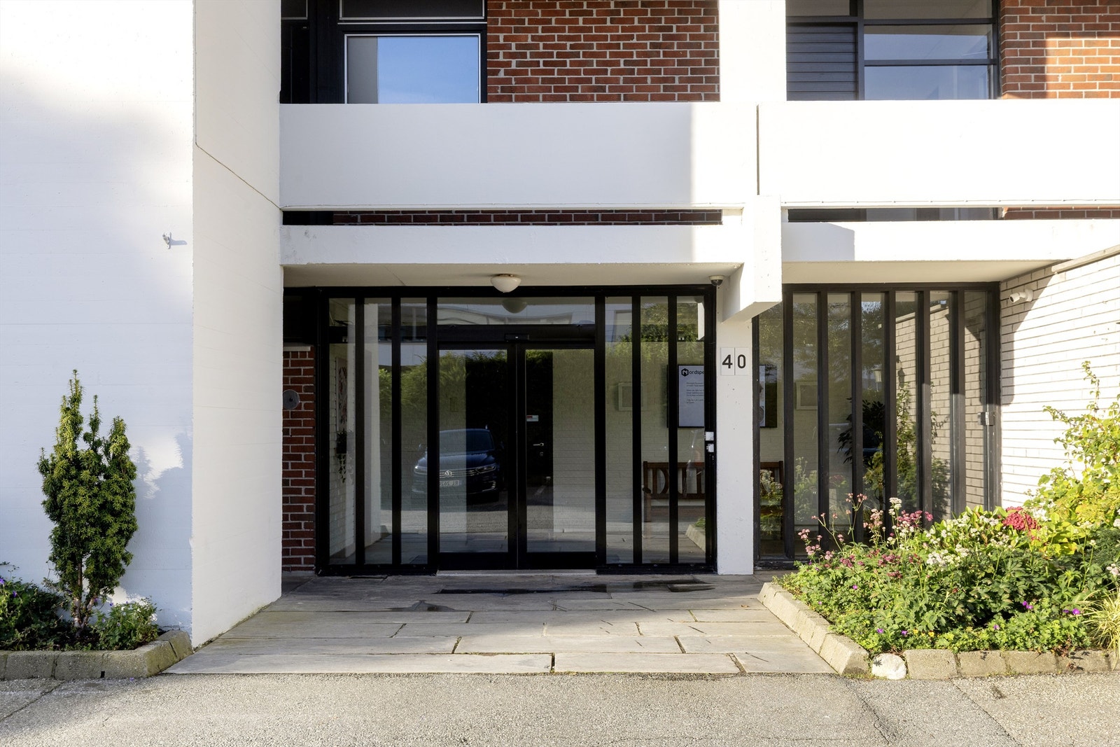 Inngangsparti ved Dues vei 40 med steinbelagt inngang og bed. Galleribilde
