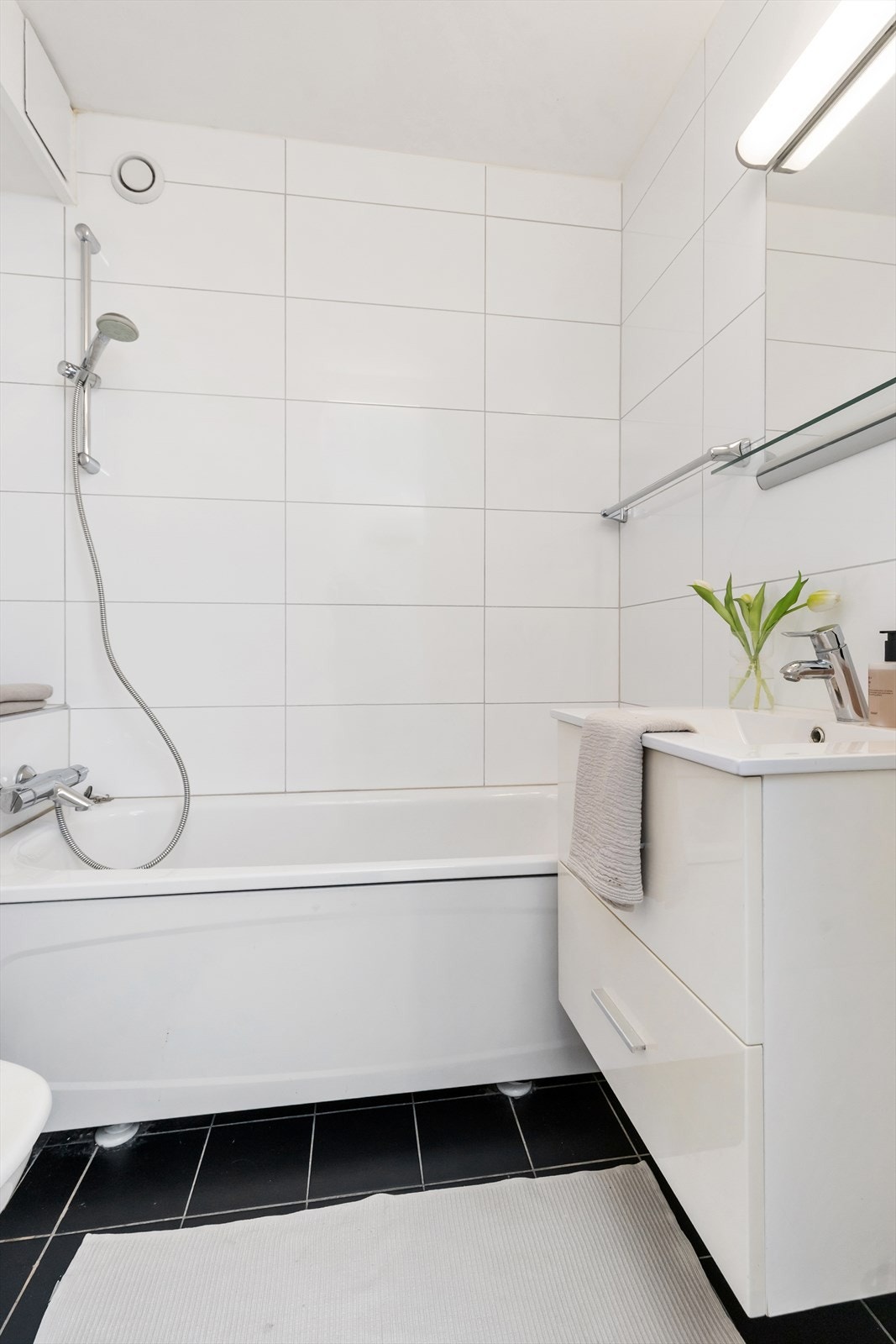 Baderommet er utstyrt med badekar, vegghengt servantinnredning og toalett. Galleribilde
