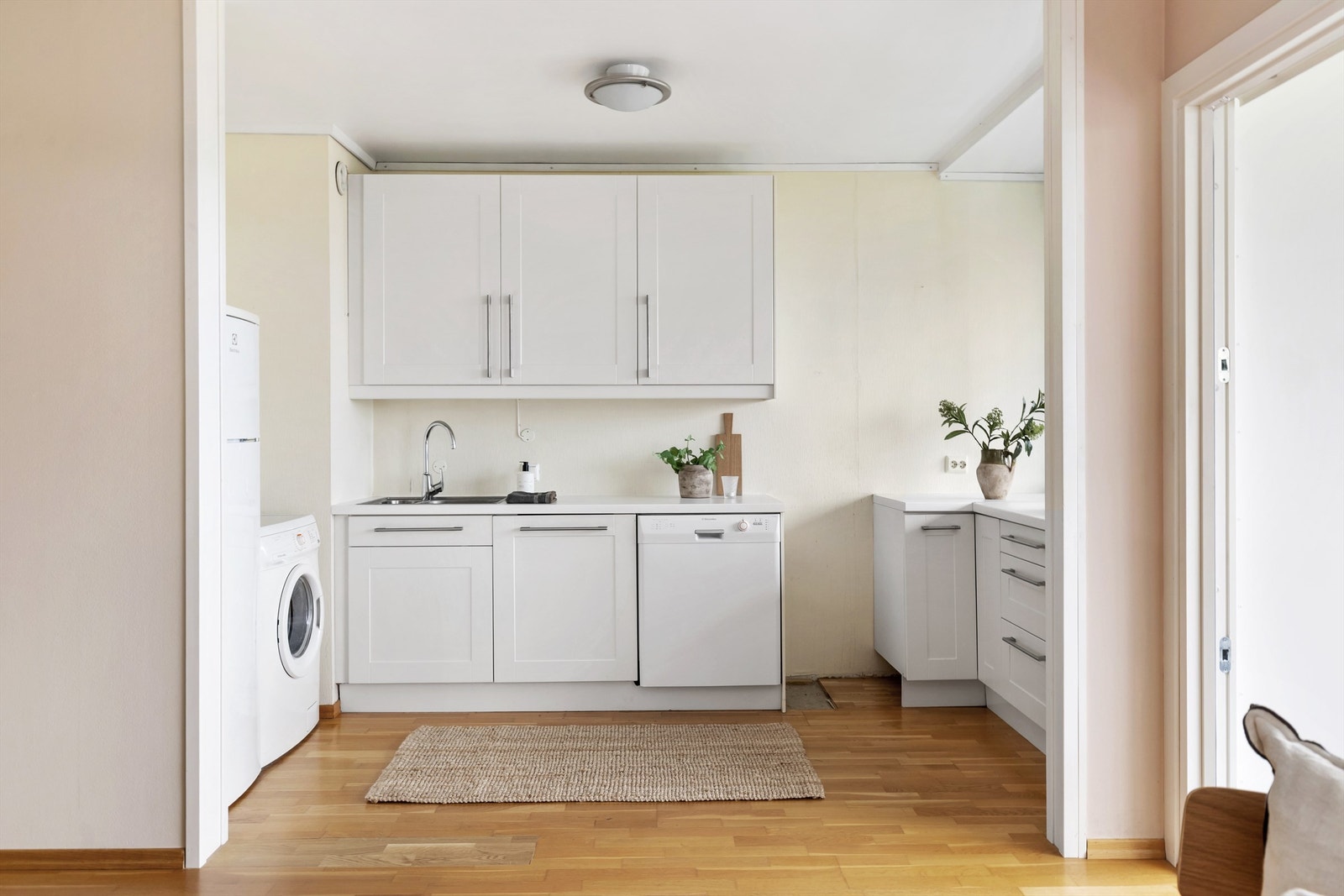 Kjøkkeninnredning med profilerte fronter og benkeplate med laminert overflate. Kjøkkenet har nedfelt vask med armatur samt benkeskapsbelysning. Galleribilde