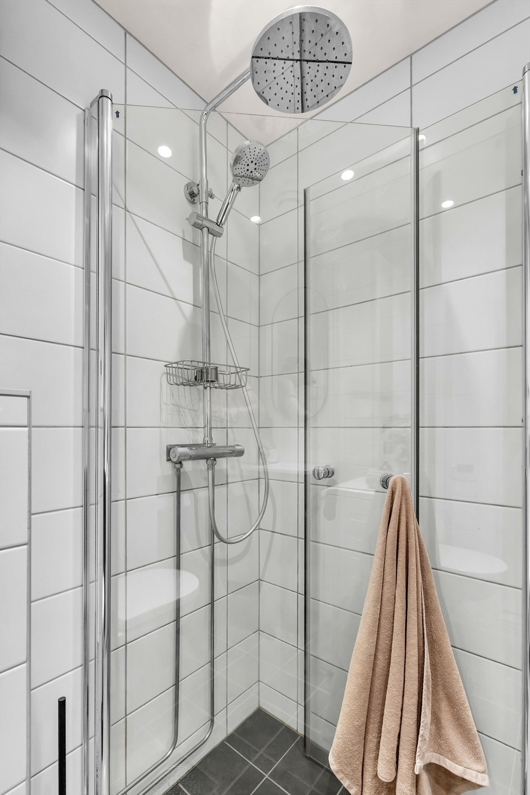 Badet har moderne og tidløse fliser, samt vannfallsdusj med innsvingbare dører. Galleribilde